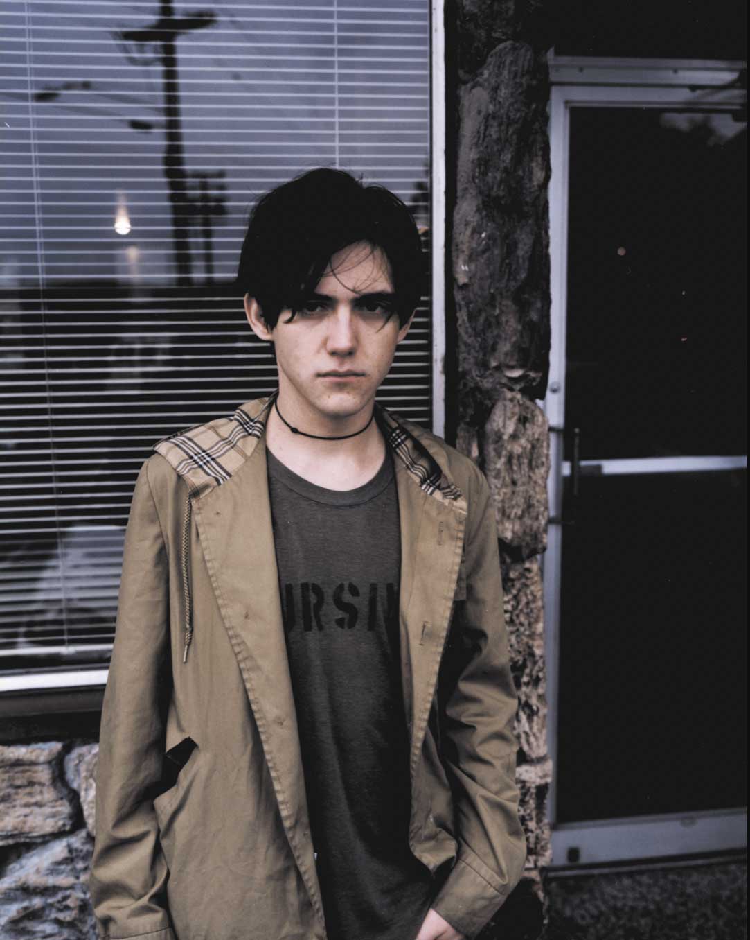 Conor Oberst standing in front of a window